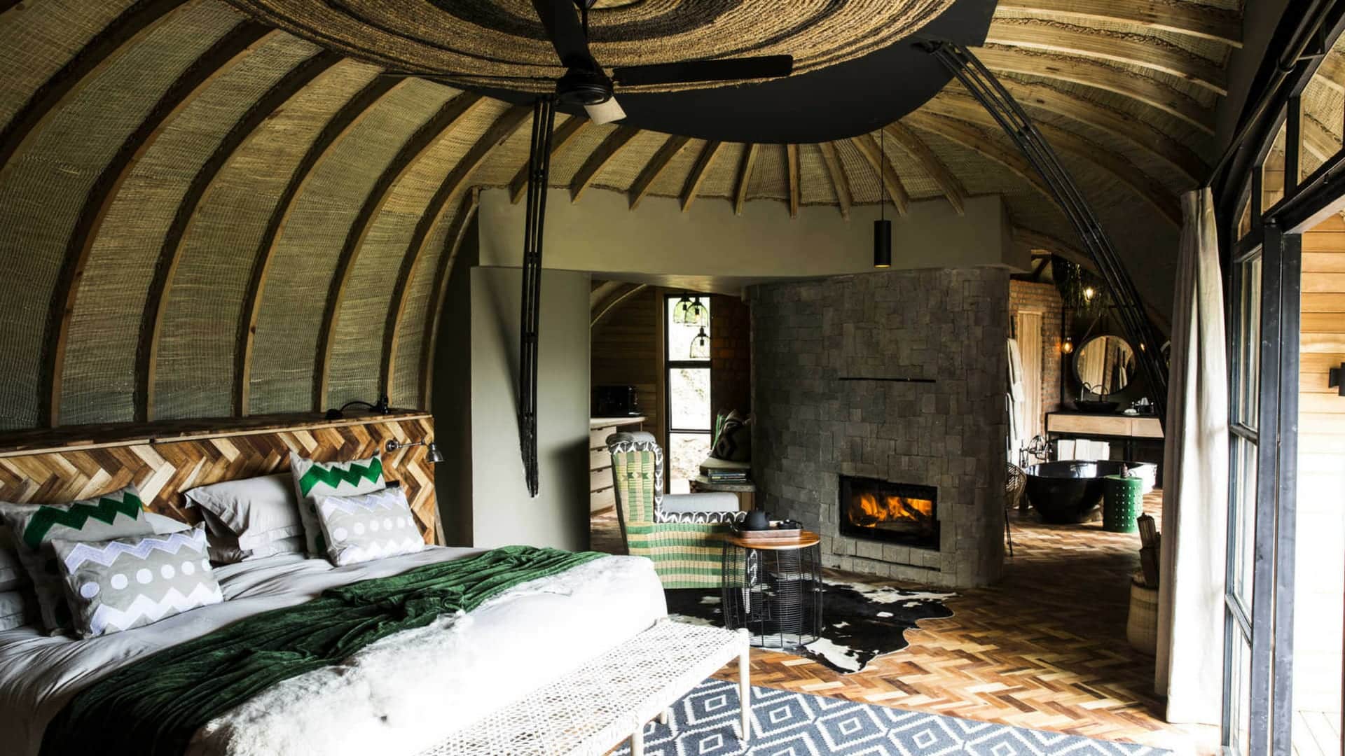 A dome shaped bedroom with indoor fireplace at Bisate Lodge - Rwanda