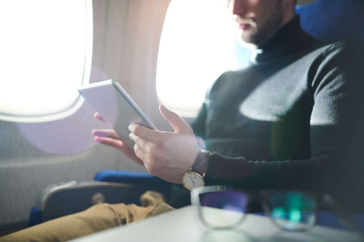 Man Using Tablet In Airplane